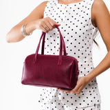 Orchid Large | Model wearing mini duffle shaped handbag with crossbody strap