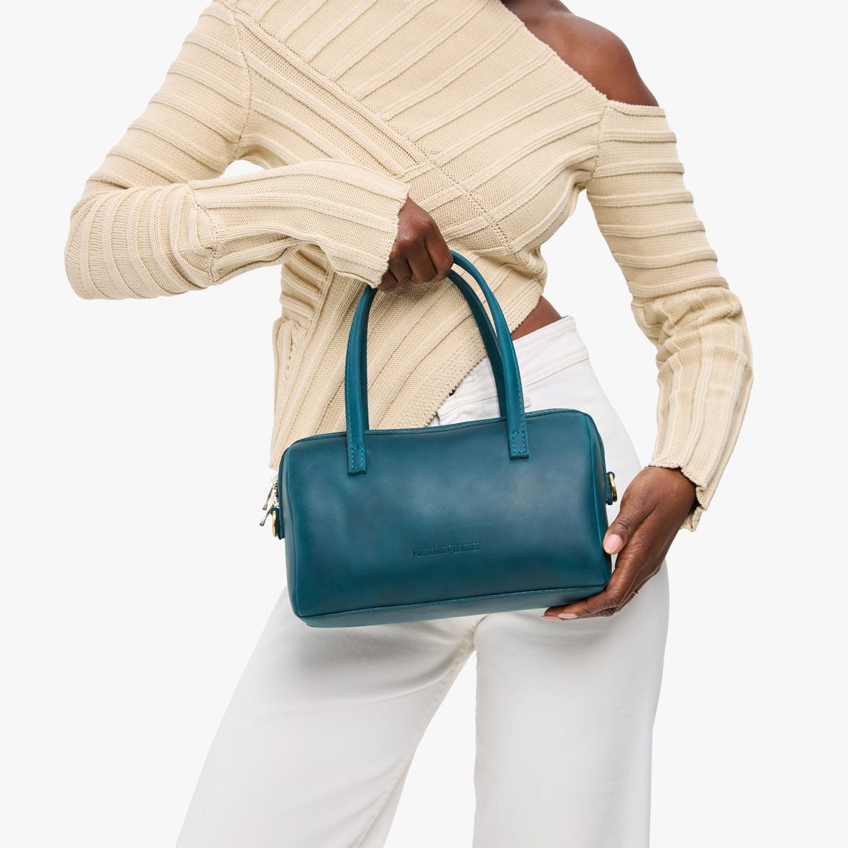 Westward Blue*Large | Model holding mini duffle shaped handbag with crossbody strap