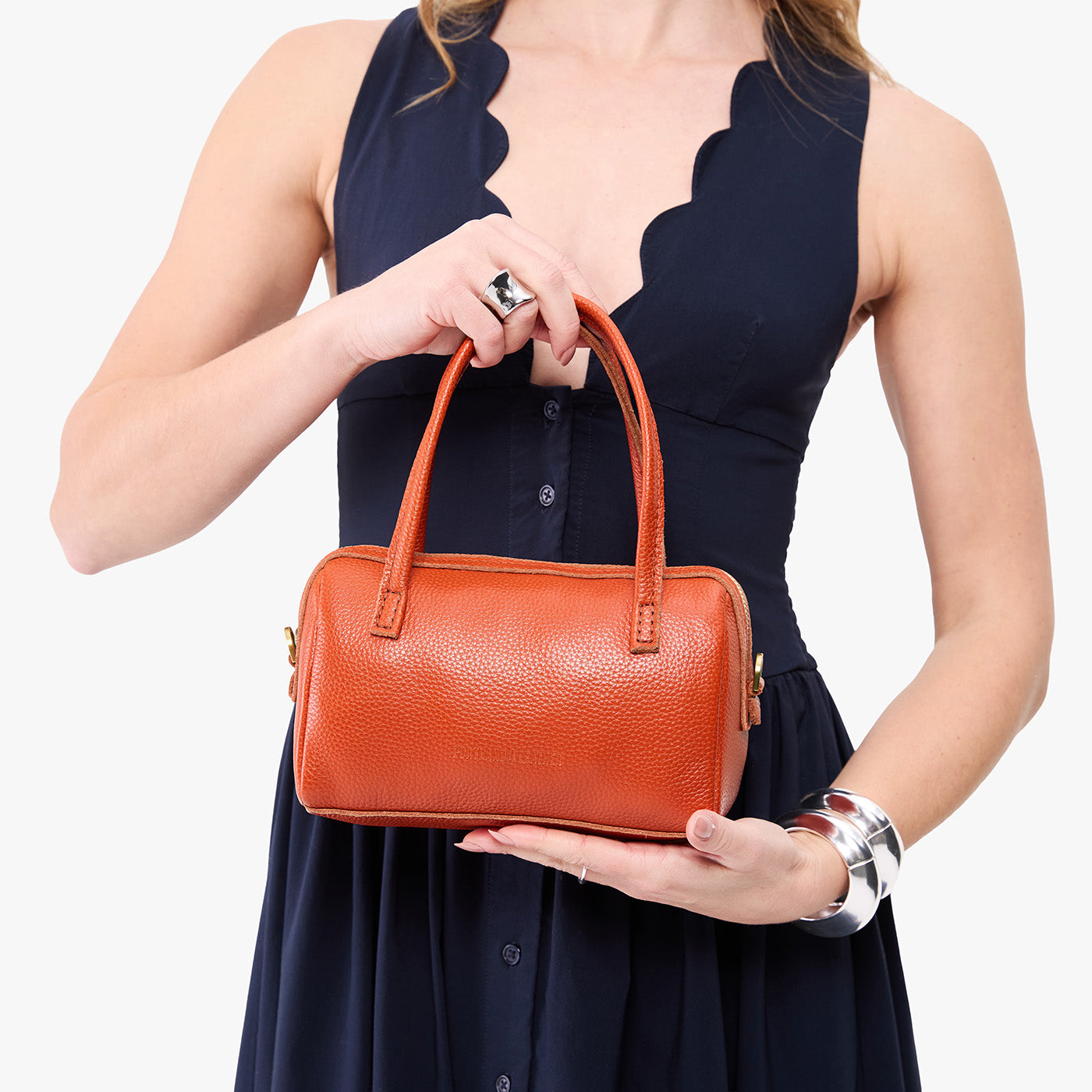 Koi*Small | Model holding mini duffle shaped handbag with crossbody strap