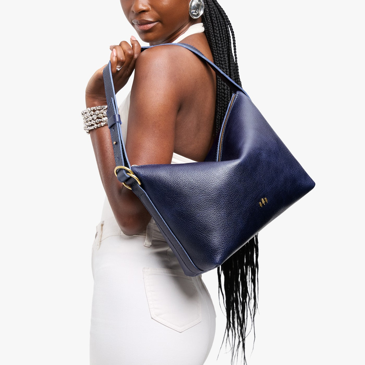 Cobalt*Large | Model Wearing medium sized slouchy leather shoulder bag with zipper opening and three metal tree emblems
