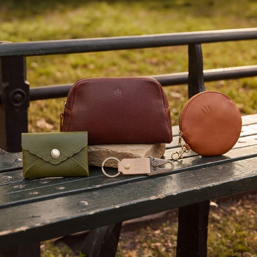 leather accessories arranged on a park bench featured image