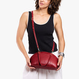 Chili Red Small | Model holding a half circle crossbody bag with handles and removable crossbody strap 