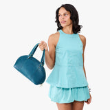 Planetary Small | Model holding a half circle crossbody bag with handles and removable crossbody strap 