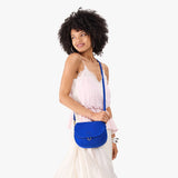 Blue Joy Small | Model wearing a petite leather Crossbody with a flap and magnetic closure