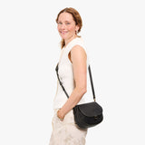 Full Moon Small | Model wearing a leather Crossbody with a flap and magnetic closure