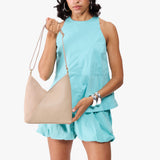 Toasted Oat Small | Model holding petite shoulder bag with adjustable strap and magnetic snap closure