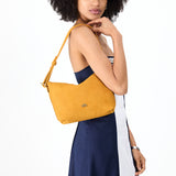 Dijon Small | Model holding a Slouchy Shoulder Bag that has a zipper opening and three metal tree emblems