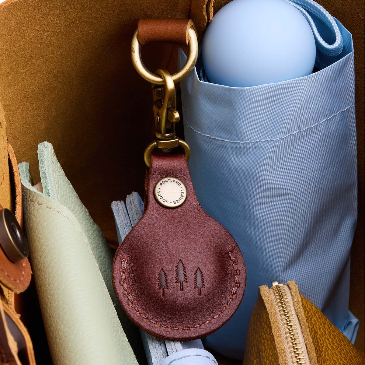 Cognac | Round leather AirTag holder with snap closure and swivel lobster claw clasp