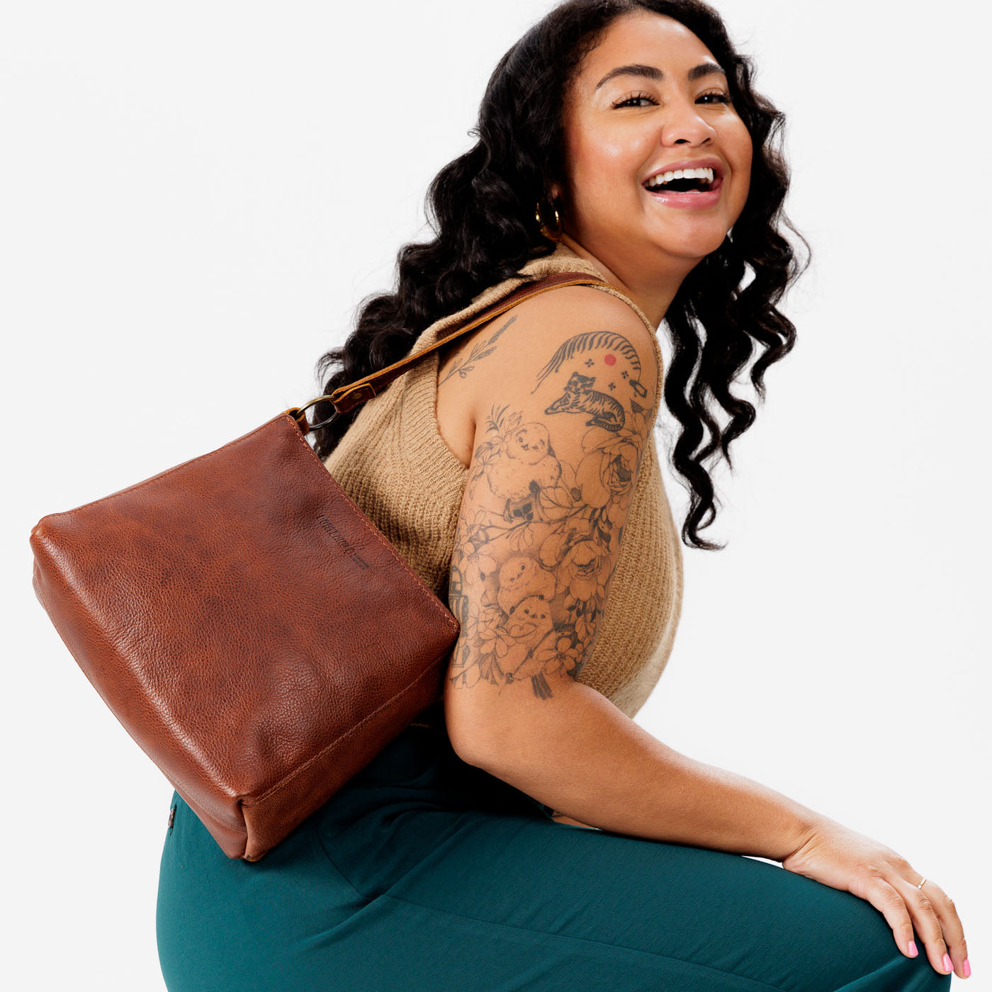 Nutmeg*Classic | Model carrying triangular shoulder bag with antiqued brass finished hardware