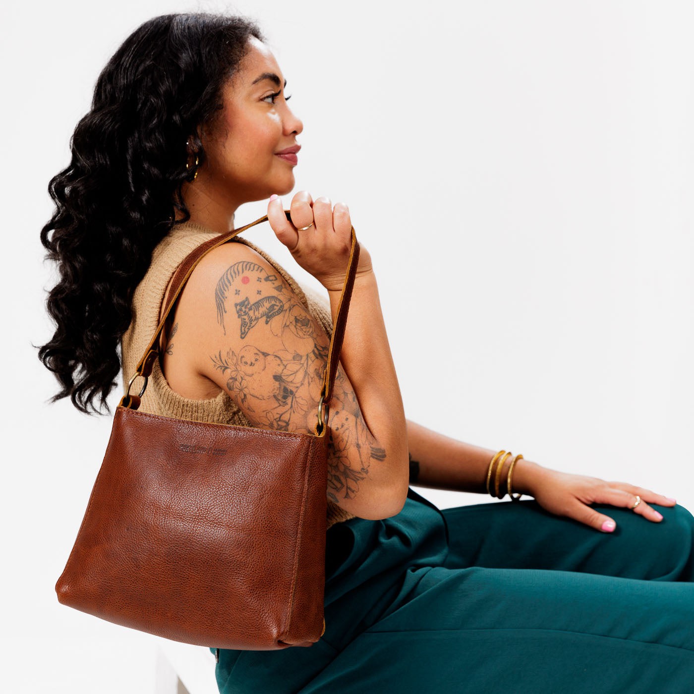 Nutmeg*Classic | Model carrying triangular shoulder bag with antiqued brass finished hardware