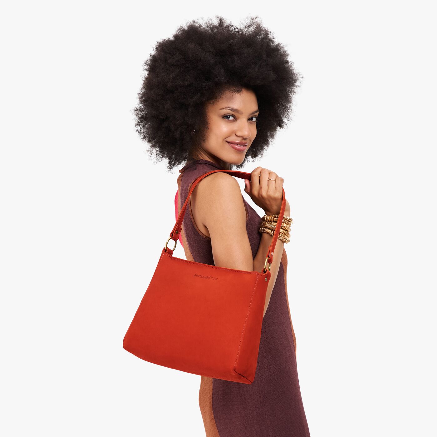 Paprika*Small | Model holding a triangular shoulder bag with antiqued brass finished 