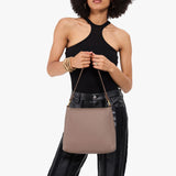 Sparrow Small | Model holding a triangular shoulder bag with antiqued brass finished 