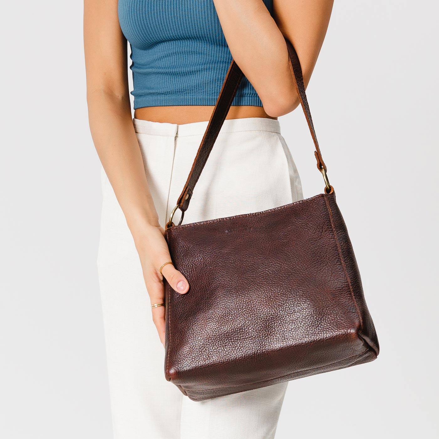 Coldbrew*Classic | Model holding triangular shoulder bag with antiqued brass finished hardware