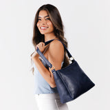 Cobalt Classic | Model carrying triangular shoulder bag with antiqued brass finished hardware