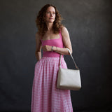Jasmine | Model holding a triangular shoulder bag with antiqued brass finished 