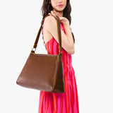 Asheville Large | Model carrying large triangular shoulder bag with antiqued brass finished hardware