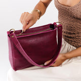 Orchid Classic | Model holding triangular shoulder bag with antiqued brass finished hardware