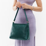 Sea Glass Classic | Model holding triangular shoulder bag with antiqued brass finished hardware