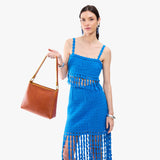 Sienna Small | Model holding triangular shoulder bag with antiqued brass finished hardware