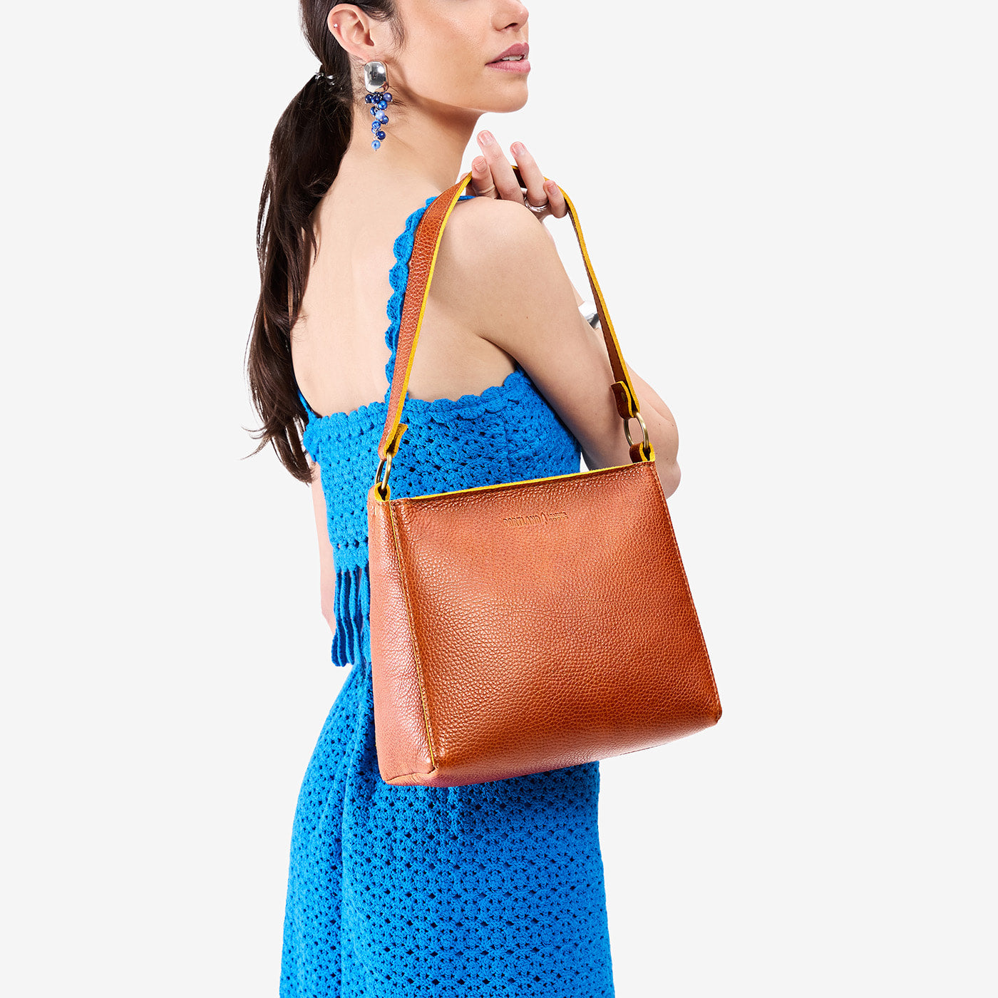 Sienna*Small | Model holding triangular shoulder bag with antiqued brass finished hardware