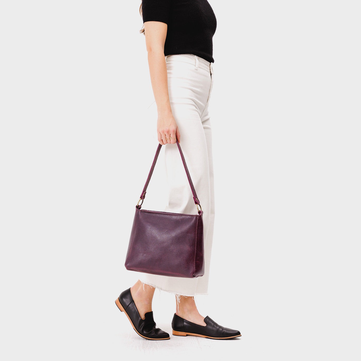 Plum*Small | Model carrying triangular shoulder bag with antiqued brass finished hardware