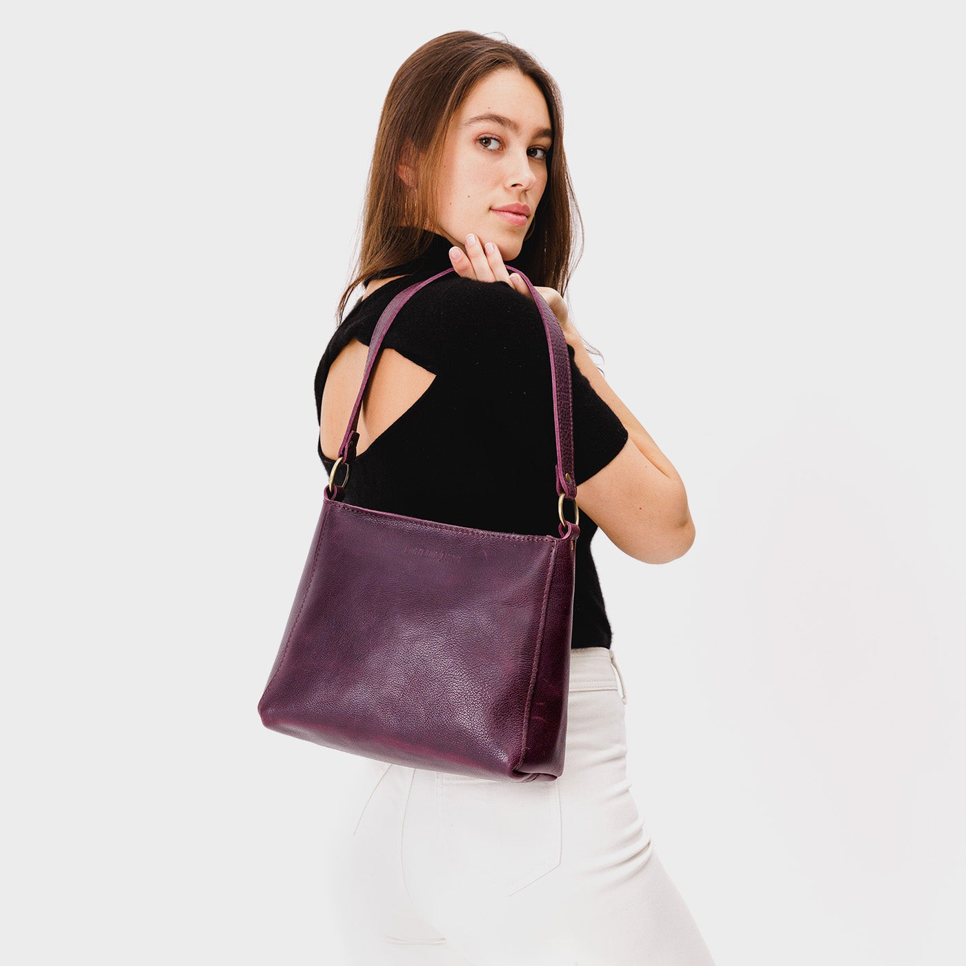 Plum*Small | Model carrying triangular shoulder bag with antiqued brass finished hardware