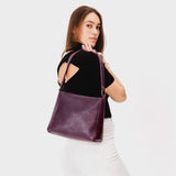 Plum Small | Model carrying triangular shoulder bag with antiqued brass finished hardware