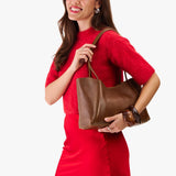 Asheville Medium | Woman in a red outfit holding wide tote with leather straps and snap closure