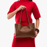 Asheville Medium | Woman in a red outfit holding wide tote with leather straps and snap closure