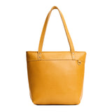 Sunshine Medium Zipper | Model wearing leather tote bag with riveted straps and exterior key loop