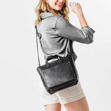 Black Zipper | Model holding crossbody tote bag with zipper closure and front pocket